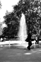 Man walking past fountain